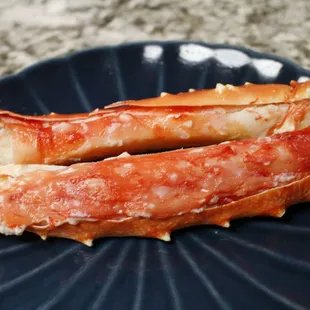 two crab legs on a blue plate
