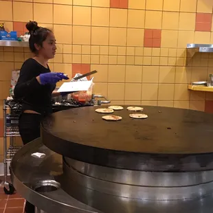 a woman preparing food in a restaurant kitchen