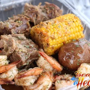 a container of seafood and corn on the cob