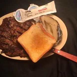 a plate of food including a sandwich, steak, and potato chips