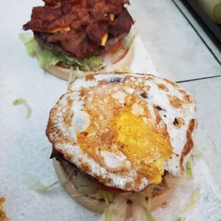 two burgers with an egg on top