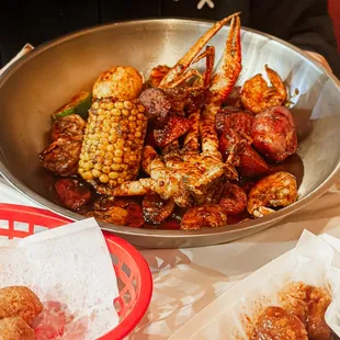 a bowl of shrimp, corn, and potatoes