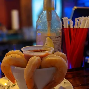 a bowl of shrimp and a bottle of beer
