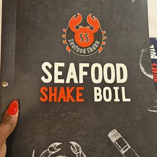 a hand holding a menu