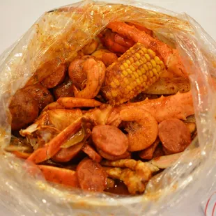 crab legs, corn, and sausage in a plastic bag