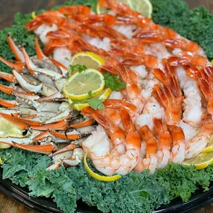 a platter of shrimp, crab legs, and kale chips