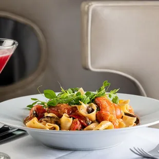 a bowl of pasta and a glass of wine