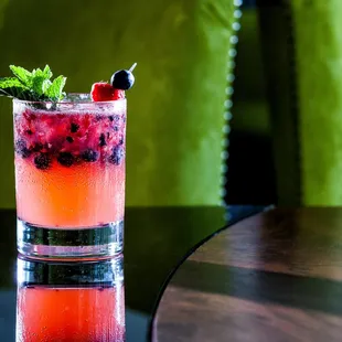 a glass of fruity drink on a table