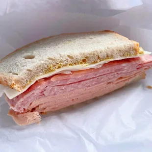 Cross section: Combo meat sandwich with onions, tomatoes, cheese, mayo, mustard. They ran out of lettuce.