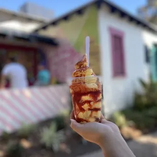 a hand holding a cup of ice cream
