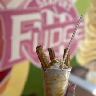 a hand holding a cup of ice cream
