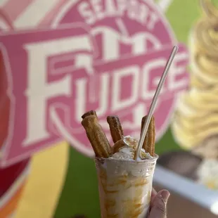 a hand holding a cup of ice cream