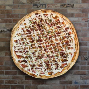 a pizza on a brick wall