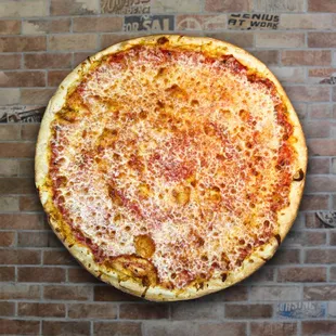 a cheese pizza on a brick wall