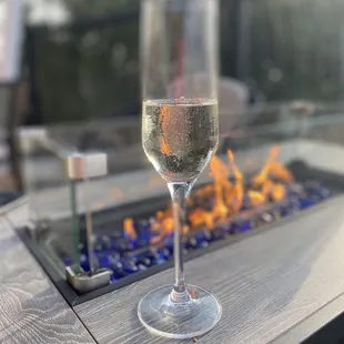 a glass of wine on a fire pit