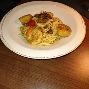 a plate of pasta with shrimp and vegetables