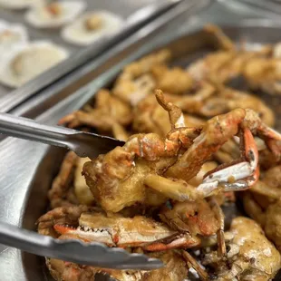 crab legs in a bowl with tongs