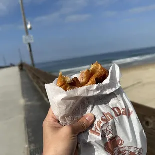 a person holding a bag of donuts