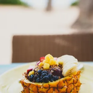a pineapple topped with fruit