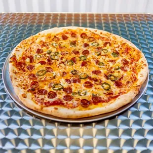 a pizza with pepperoni, jalapenos, and cheese