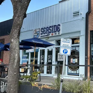 the outside of a restaurant with blue umbrellas