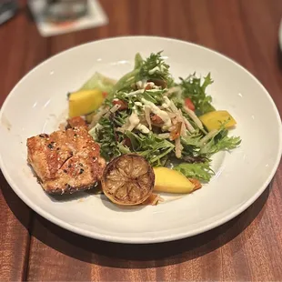 SESAME-GRILLED SALMON: organic greens, mango, jicama, lemongrass seuce, wood-grilled red peppers, toasted sesame dressing (split) | $24