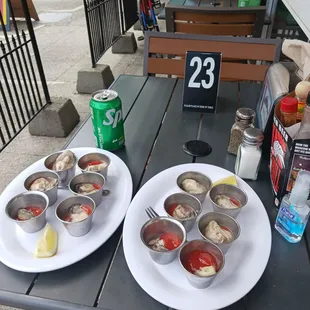 two plates of clams on a picnic table