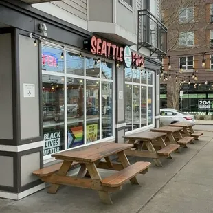 a row of picnic tables in front of a store