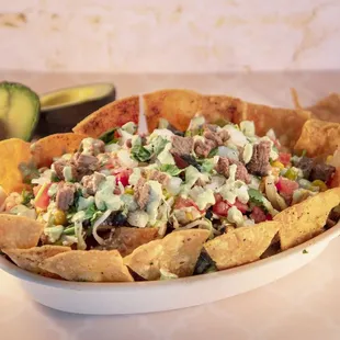 Bowl with a Nacho Base and our carne asada steak!