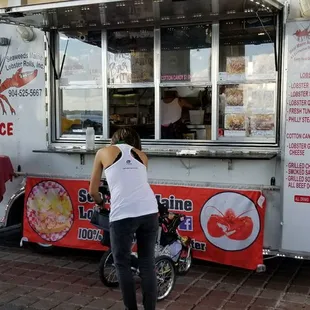 a woman standing in front of a food truck