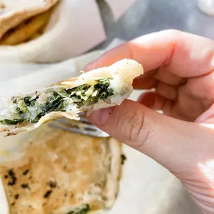 a hand holding a half eaten sandwich