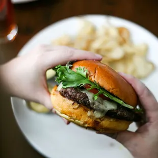 a person holding a hamburger