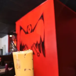 a hand holding a glass of iced coffee