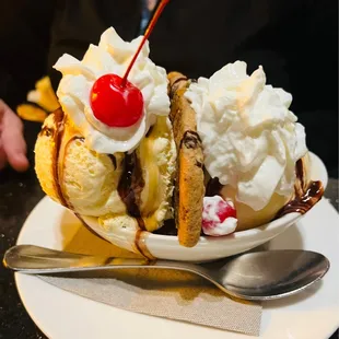 a banana split with whipped cream and a cherry on top