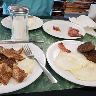 a plate of eggs, bacon, and sausage