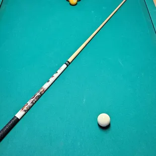 a pool table with a pool cue and balls