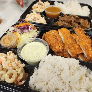 a tray of food with rice, macaroni and cheese