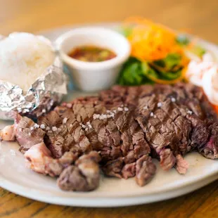 SUA RONG HAI - A famous Thai style charbroiled rib-eye steak served with spicy and sour rice powdered dipping sauce and sticky rice.