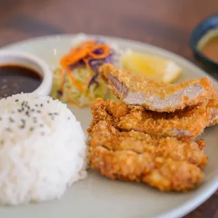 TONKATSU -  Deep-fried pork cutlet over rice in healthy drizzle of tonkatsu sauce served with shredded cabbage salad  and seaweed soup.