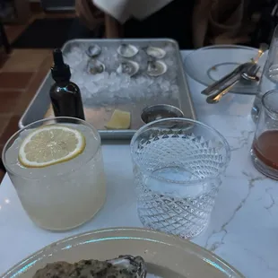 a plate of oysters and a glass of lemonade