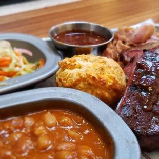 a plate of meat, beans and coleslaw
