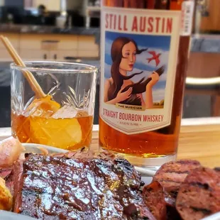 a plate of food and a bottle of whiskey