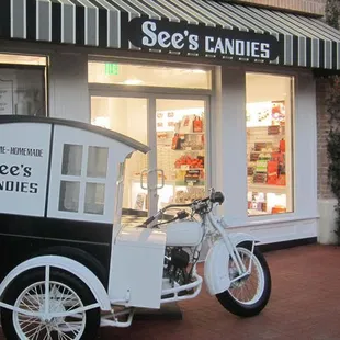 a small ice cream truck parked in front of a store