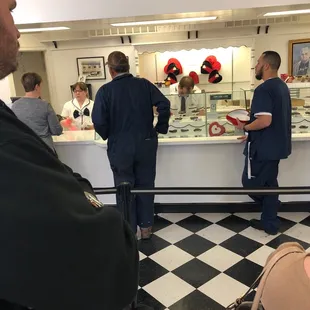 a group of people standing in line at a counter