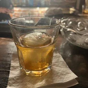 a glass of whiskey on a napkin