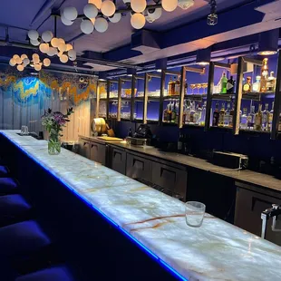 a long marble bar with blue lighting