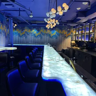 a long bar with blue chairs