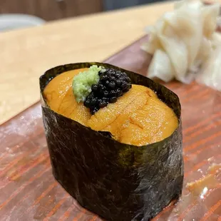 a sushi with blackberries on top