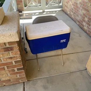 a cooler sitting on a chair outside