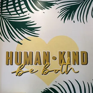 a sign with a heart and palm leaves